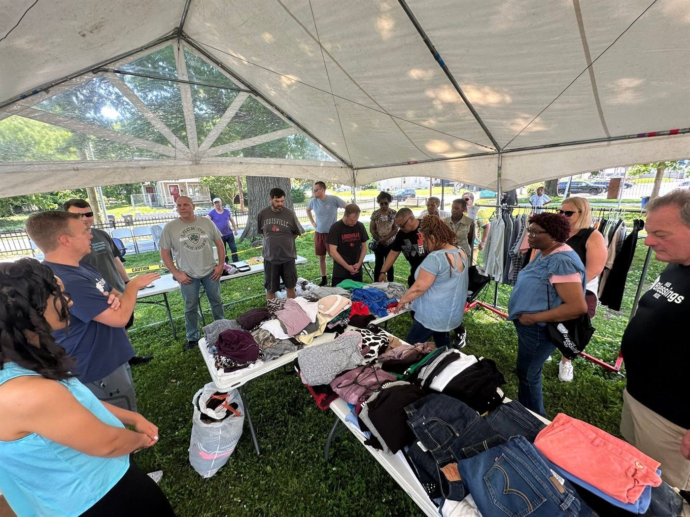 Clothing laid out on tables under a tent at a community day