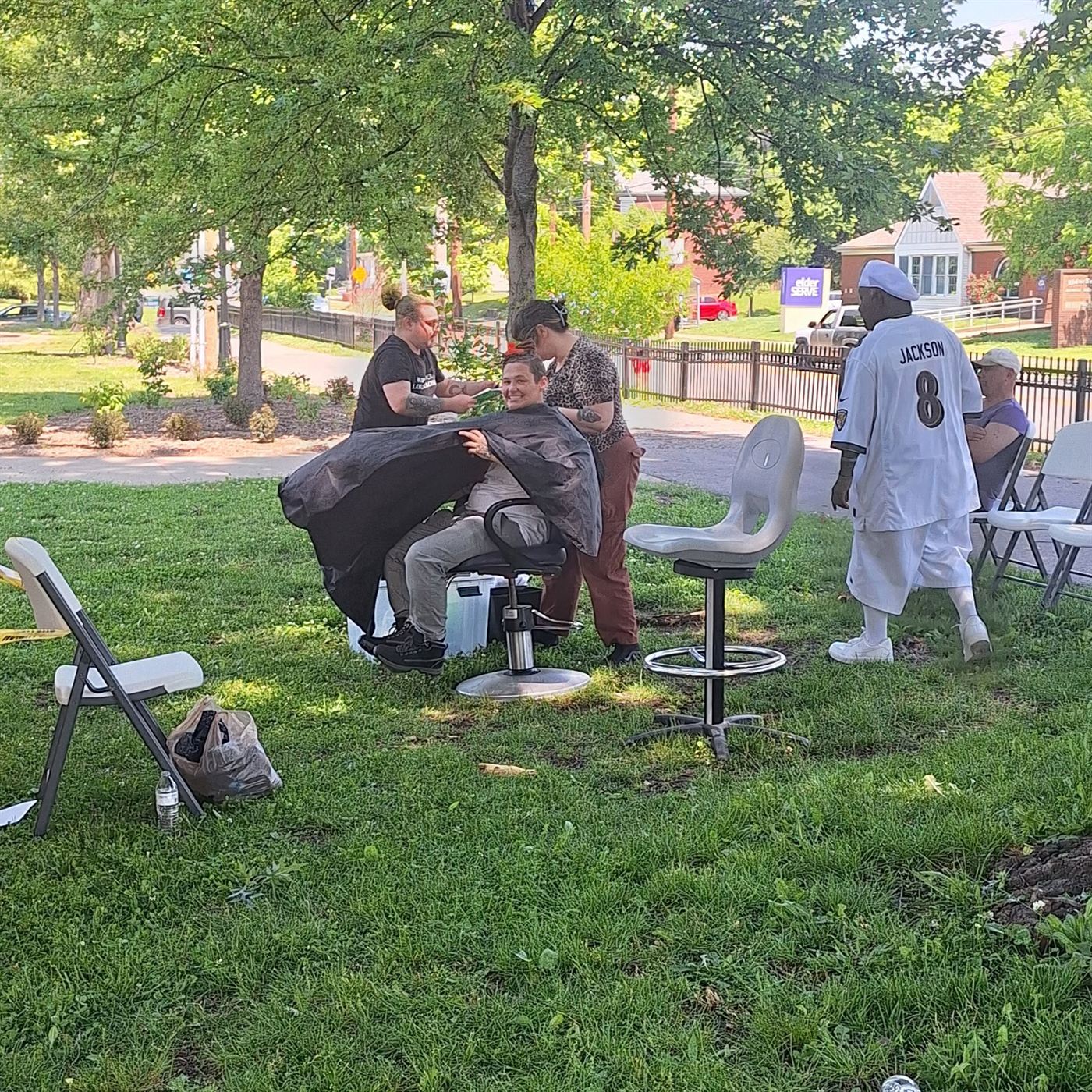 Barber chairs set up on the grass for free haircuts at a community event