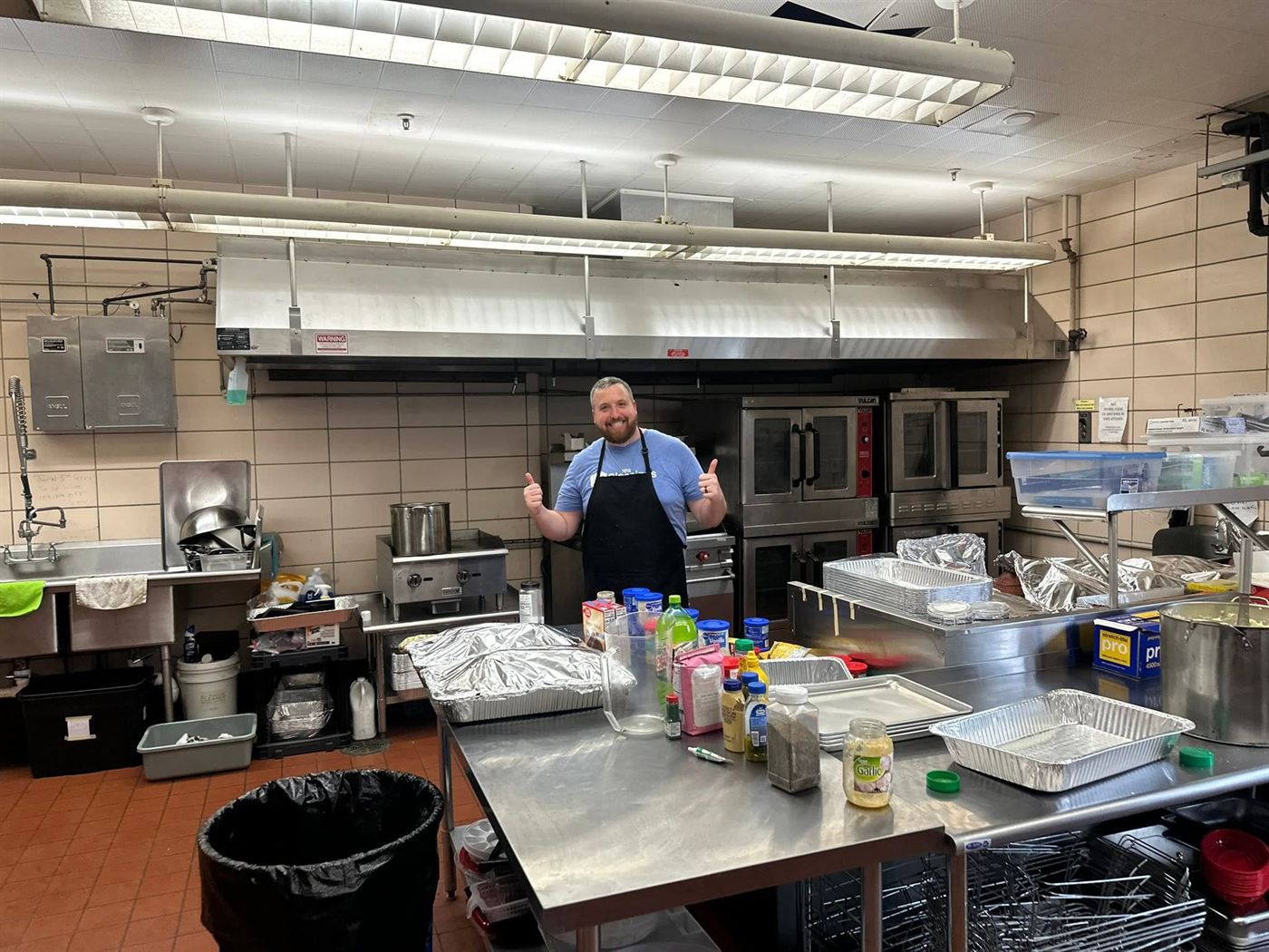A His Blessings Box volunteer cooking in the kitchen at Sanctuary Church before the Friday meal