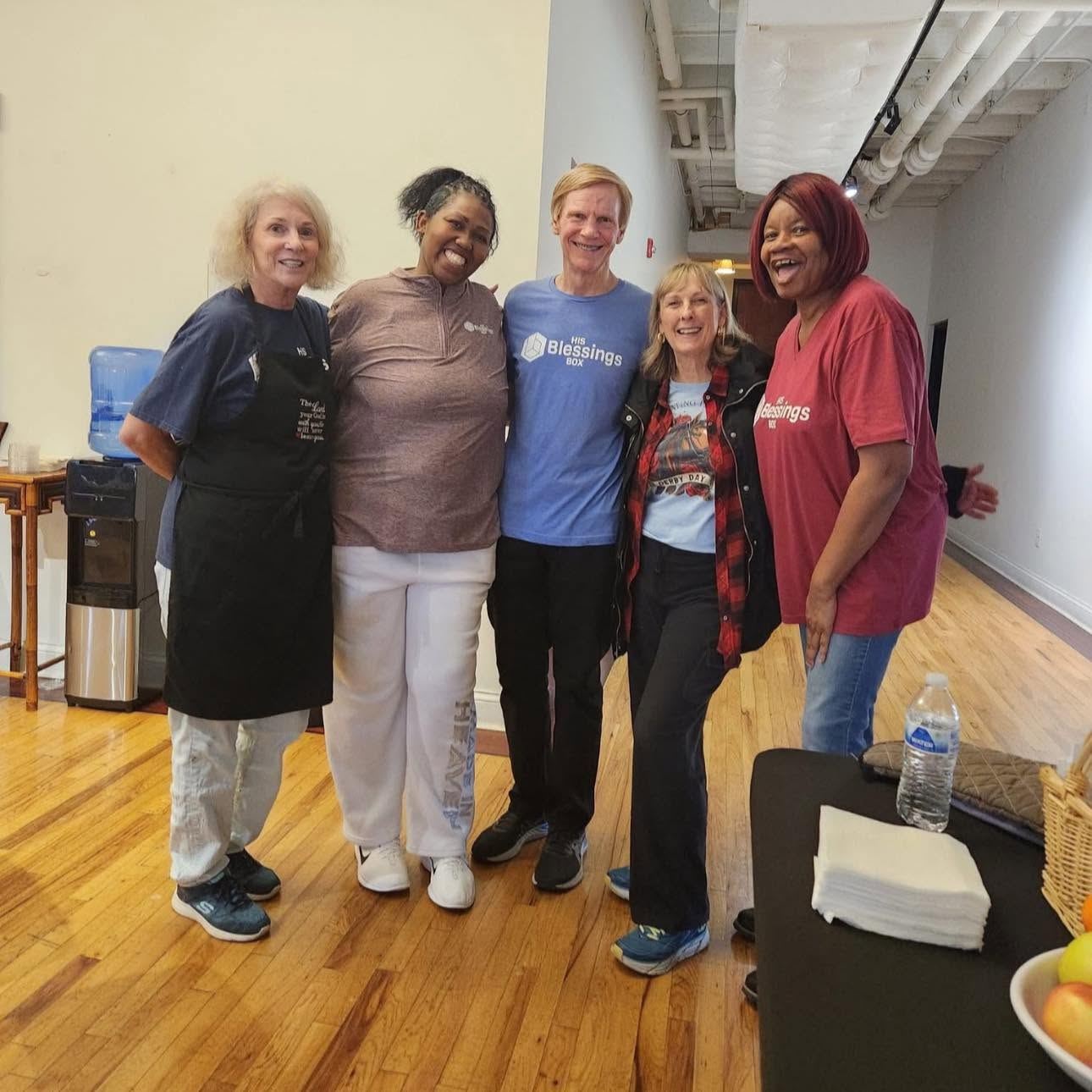 Volunteers in aprons working side by side in the kitchen