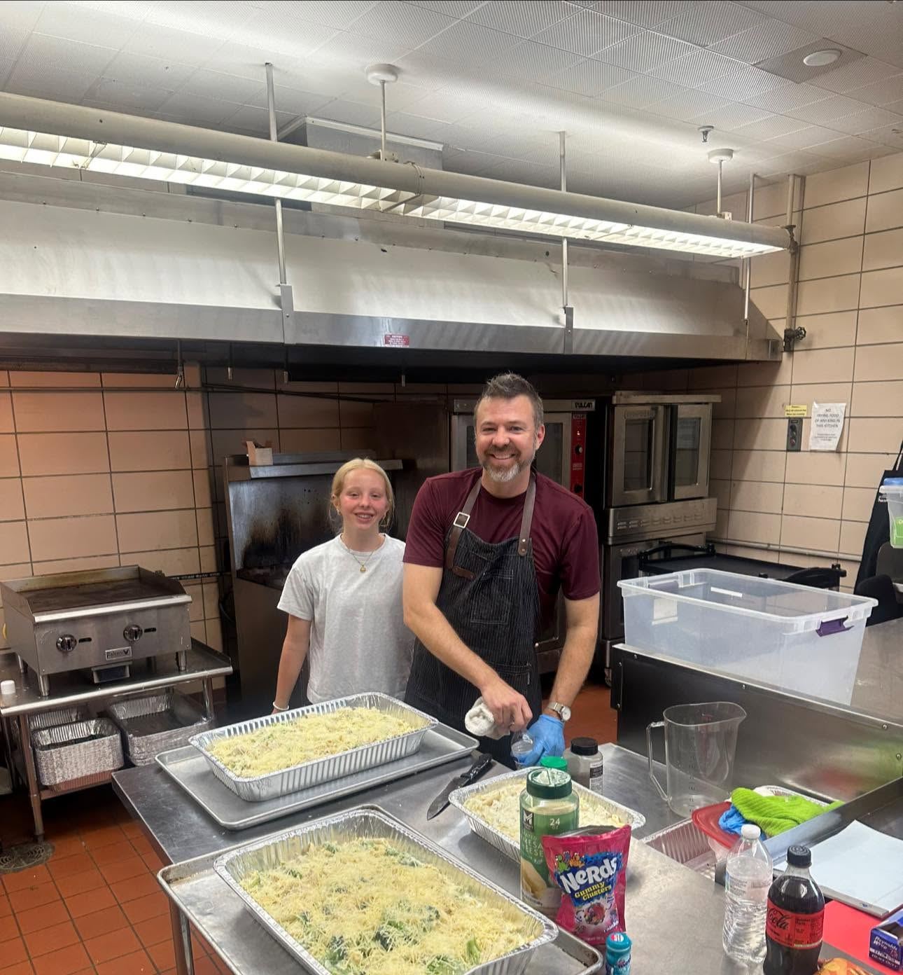 Volunteers working together in the kitchen preparing the Friday meal