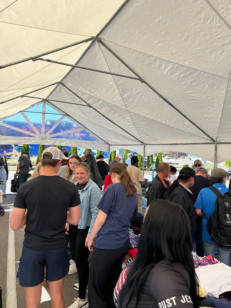 Guests and volunteers together under the big tent at a community day